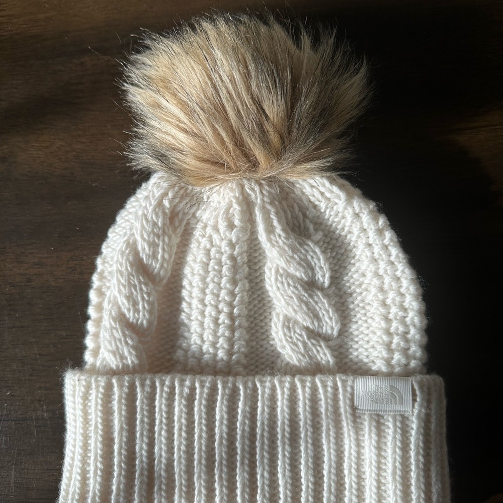 The North Face Cream Cable Knit Beanie with Tan Pom-Pom